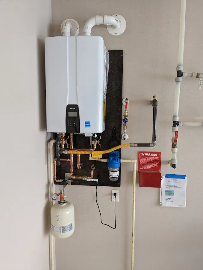 Professional plumber installing copper piping in a Hubbardston home